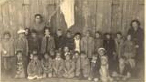 גן אסתר זוזובסקי, תמונה קבוצתית על רקע הגן, 1940. למיטיבים לראות, הכתובות על קיר הצריף בצד ימין. באד